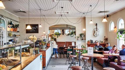 a restaurant with people sitting at tables in it at High Ceiling 6 Beds Private Garden Oasis 1min to Stadiums & Parking in Sydney