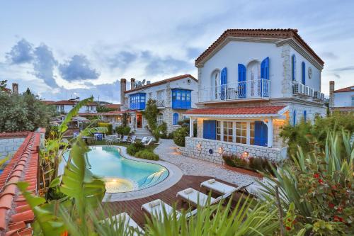 a villa with a swimming pool and a house at Cumbali Konak Hotel (Adults Only +12) in Alaçatı