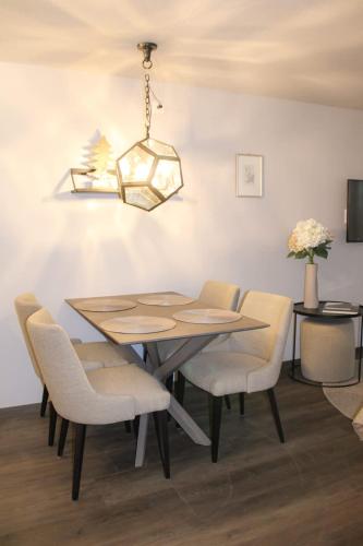 a dining room table with chairs and a chandelier at Attinook - Quiet Studio, 5 Min to Matterhorn Lifts in Zermatt