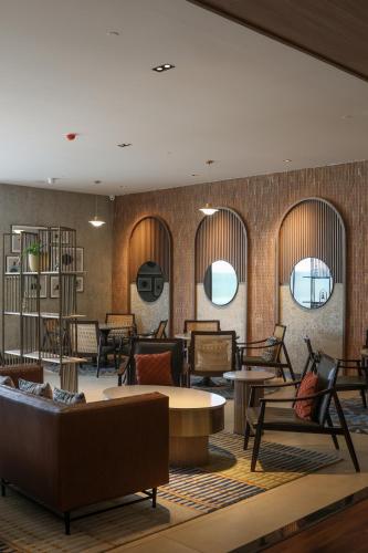 a lobby with couches and tables and chairs at Radisson Resort Hatgad Saputara in Saputara