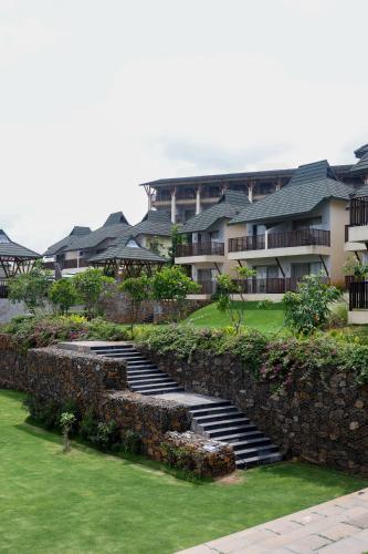 a building with stairs in front of a yard at Radisson Resort Hatgad Saputara in Saputara
