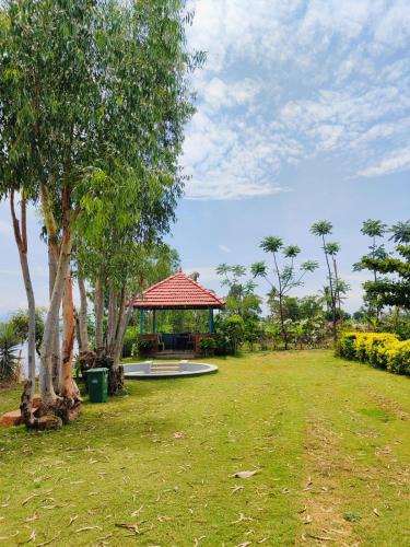 a park with a gazebo and trees and grass at Medini Ecostay - Your Private Paradise in Kollegālam