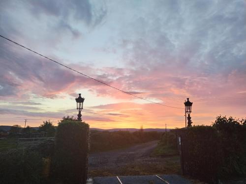 two lights on a road with a sunset in the background at The Burren Art Gallery built in 1798 in Tubber