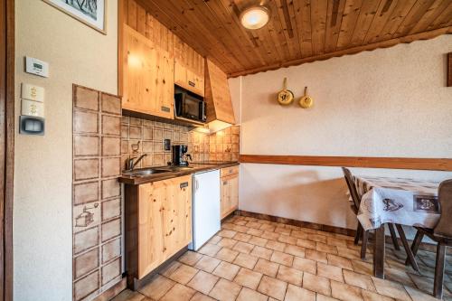 a kitchen with a sink and a table with chairs at La Flèche d'Or in Châtel