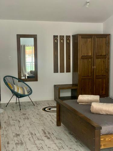 a bedroom with a bed and a chair and a mirror at Комплекс Варвара - Хотел, Аквапарк и Минерлни басейни in Varvara