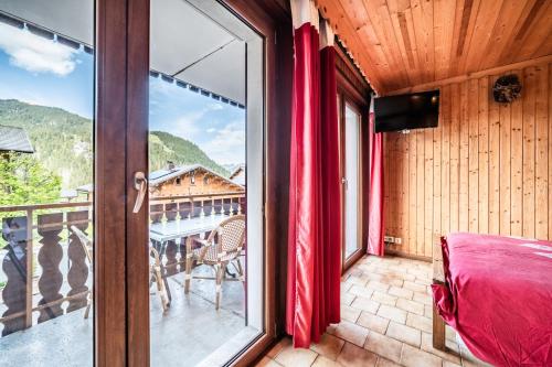 a room with a view of a balcony with a table at La Flèche d'Or in Châtel