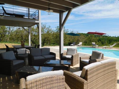 une terrasse avec des chaises, une table et une piscine dans l'établissement La DEMEURE DE FONLAVEVE, à Veyrines-de-Domme
