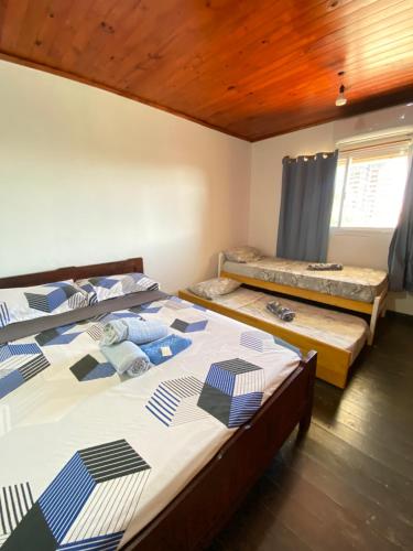 a bedroom with two beds and a wooden ceiling at Duplex Urbano in Puerto Iguazú