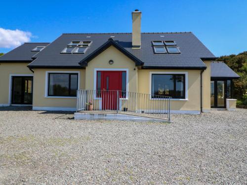 a house with a red door on a gravel driveway at Curraha in Kenmare
