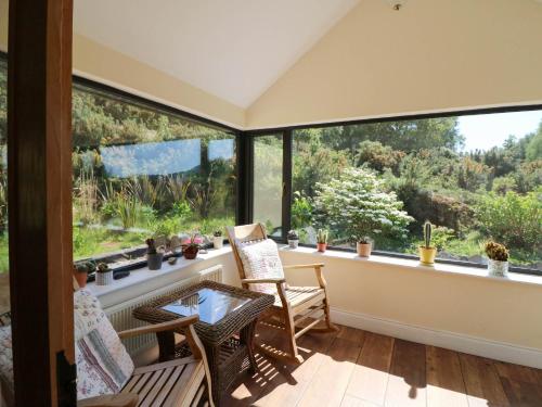 a screened in porch with a view of the garden at Curraha in Kenmare