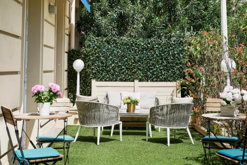 patio con sedie e tavolo con fiori di Nice Excelsior Centre ville by HappyCulture a Nizza