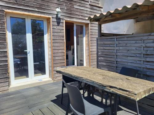une terrasse en bois avec une table et des chaises en bois dans l'établissement A la campagne, à Saint-Denis
