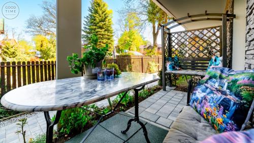 a patio with a table and a bench at Apartamenty Good Time - Belle View - Centrum in Szklarska Poręba