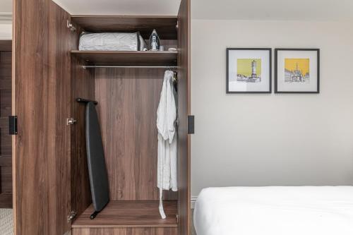 a bedroom with a wooden closet with a bed at Mercure Salisbury White Hart Hotel & Apartments in Salisbury