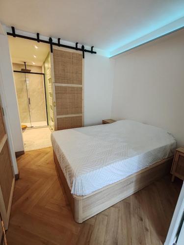 une chambre avec un lit et une porte coulissante en verre dans l'établissement 2P apaisant proche Mer et Golf Cannes Mandelieu, à Mandelieu-la-Napoule
