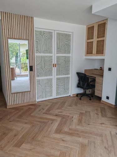 un salon vide avec une porte et un bureau dans l'établissement 2P apaisant proche Mer et Golf Cannes Mandelieu, à Mandelieu-la-Napoule