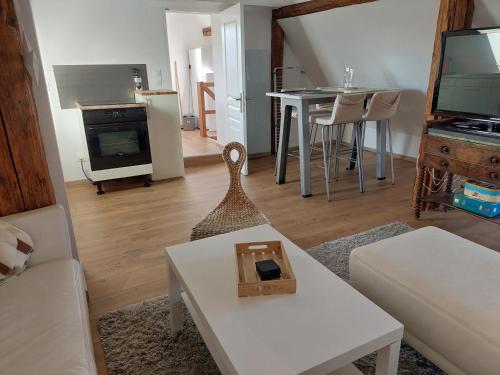 un salon avec un canapé et une table dans l'établissement Au jardin de Lucie, à Sainte-Croix-en-Plaine