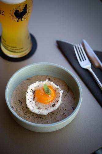 a bowl of soup with an egg on top of it at HÔTEL PANORAMA 360 Bourg en Bresse - Cœur de ville in Bourg-en-Bresse