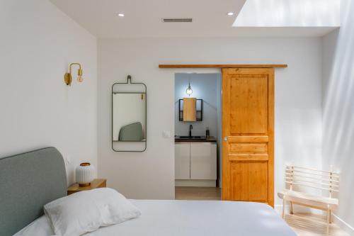 - une chambre avec un lit, un miroir et une porte dans l'établissement Duplex Vieux-Port, à Marseille