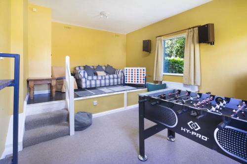a living room with a ping pong table and a couch at Stamp Howe - Great Views with garden and pub nearby in Troutbeck