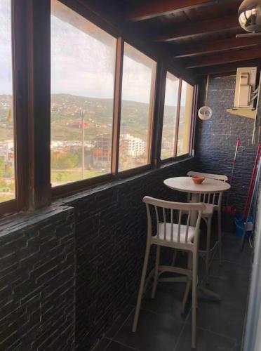 a table and chairs in a room with windows at Well equipped apartment with luxurious interior furnishings in Tangier