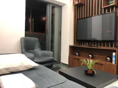 a living room with a television and a chair at Well equipped apartment with luxurious interior furnishings in Tangier