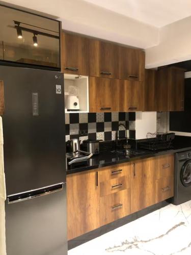 a kitchen with wooden cabinets and a stainless steel refrigerator at Well equipped apartment with luxurious interior furnishings in Tangier