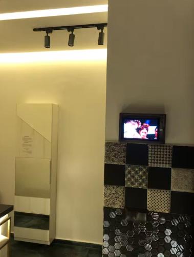 a room with a tv on a wall with a checkered floor at Well equipped apartment with luxurious interior furnishings in Tangier