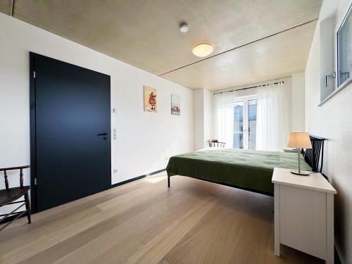 ein Schlafzimmer mit einem grünen Bett und einer schwarzen Tür in der Unterkunft bonquartier - Luxus in Natur - Penthouse nah Bonn in Wachtberg