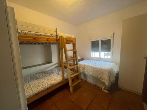 a bedroom with two bunk beds and a window at Lovely 10-Bed Villa with Private Pool & Garden in Cacin