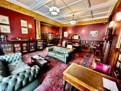a living room with couches and chairs in a library at The Cape Town Club in Cape Town