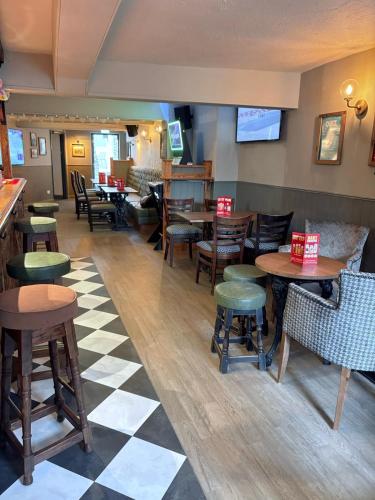 a restaurant with wooden tables and chairs and a checkered floor at Blue Boar in Frome