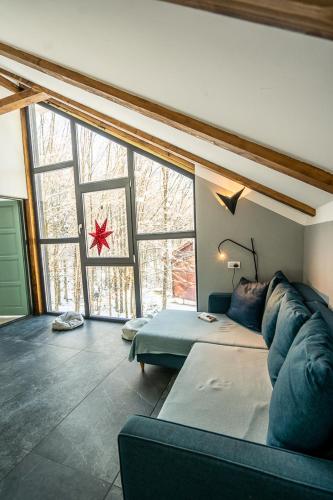 a living room with a couch and a large window at Vila Blanc Valiug Crivaia in Văliug