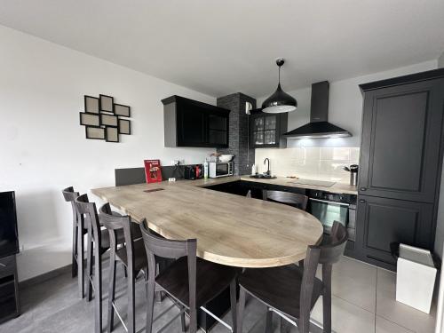 une cuisine avec une table et des chaises en bois dans l'établissement Plantation FL - 4 Pers, Spacieux, Chaleureux, à Reims