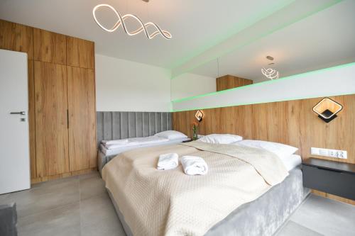 two beds in a bedroom with two white towels at Słoneczne Wzgórze Zator in Zator