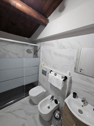 a white bathroom with a toilet and a sink at Country house "L'isola che non c'è" in Ancona