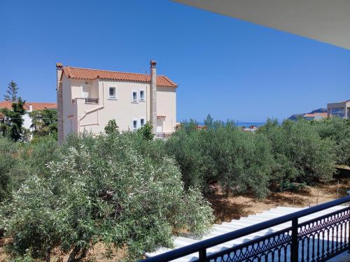 a house with a fence in front of some bushes at Monemvasia's Art House in Ayía Kiriakí