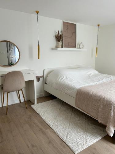 une chambre avec un lit, un bureau et un miroir dans l'établissement Cozy house 5min Enghien's Lake, à Enghien-les-Bains
