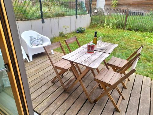 a picnic table with a bottle of wine and chairs on a deck at Le 11 - Terrasse et jardin à 10 minutes à pieds du centre-ville in Strasbourg