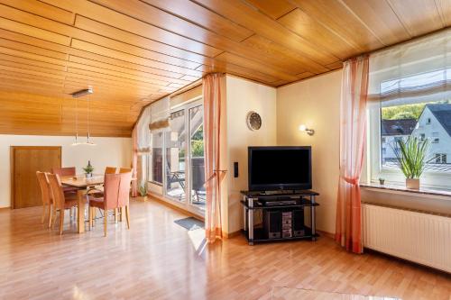 Una sala de estar con una mesa y un televisor. en Ferienwohnung Urban, en Bestwig