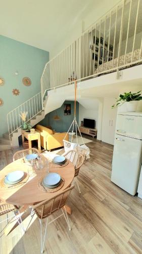 un salon avec une table et des chaises et un escalier dans l'établissement Le 11 - Terrasse et jardin à 10 minutes à pieds du centre-ville, à Strasbourg