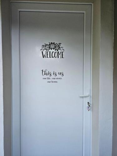 a white door with a welcome sign on it at Country house "L'isola che non c'è" in Ancona