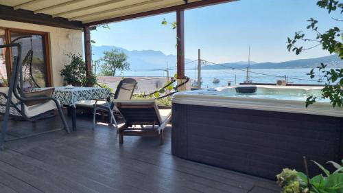 bañera de hidromasaje en una terraza con mesa y sillas en Olive Coast Apartments Baošići Center, en Herceg-Novi