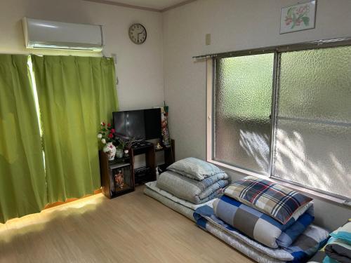 a living room with a chair and a television at ハイツドリーム梦想小屋 in Tokyo