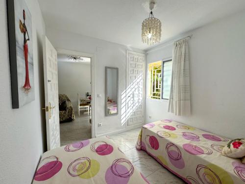 ein Schlafzimmer mit einem Bett und einem Kronleuchter in der Unterkunft Bahamas III -Sant Joan- in San Juan de Alicante