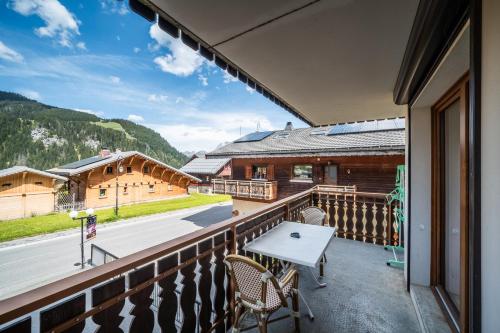 a balcony with a table and chairs and a building at La Flèche d'Or in Châtel