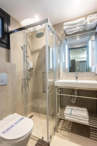 a bathroom with a shower and a toilet and a sink at Fortaleza Rooms Pefkochori in Pefkochori