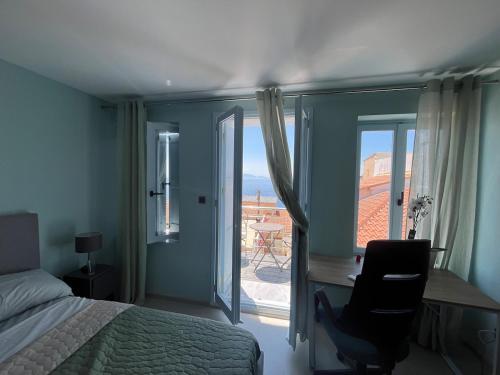 a bedroom with a bed and a desk and a window at Plomari Grey house Casa Peppe in Plomarion