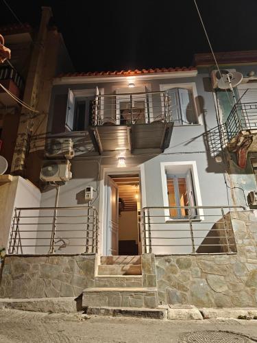 a white house with stairs in front of it at night at Plomari Grey house Casa Peppe in Plomarion