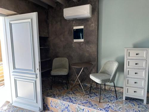 a room with two chairs and a table and a television at Plomari Grey house Casa Peppe in Plomarion